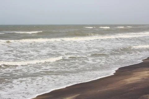 Frothy waves on beach with patterns Foto stock