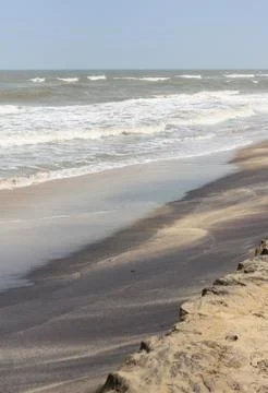 Frothy waves on beach with patterns Foto stock