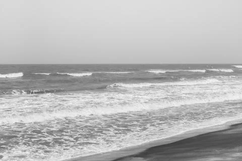Frothy waves on beach with patterns Stock Photos