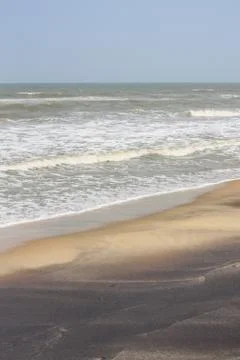 Frothy waves on beach with patterns Stock Photos