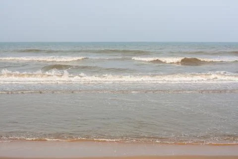 Frothy waves on beach Stock Photos