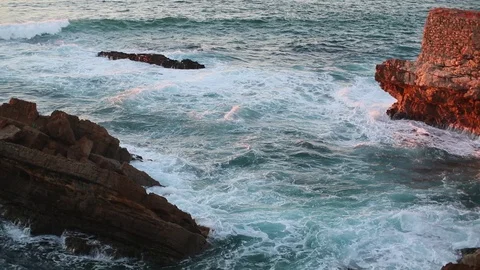 Frothy waves break against ocean shore rocks Stock Footage 130003567