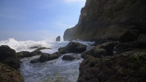 Frothy waves crashing over rocks by the Indonesian coastline Stock Footage 93781693
