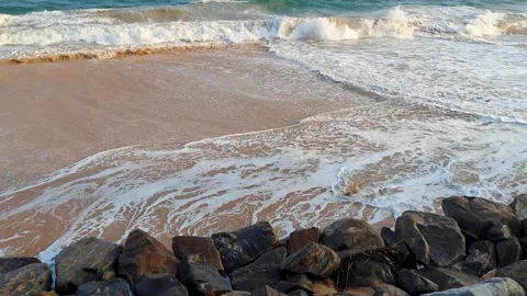 Frothy whitewash waves washing up on rocky shoreline beach in Tangalle Stock Footage 313893741