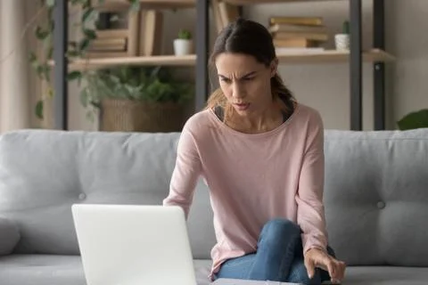 Frown woman looking on computer screen received bad news Foto stock