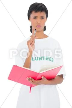 Frowning black haired volunteer holding a notebook Stock Photos