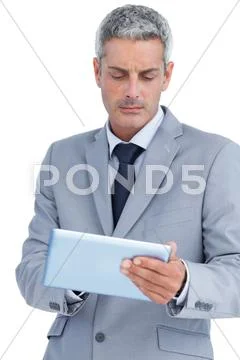 Frowning businessman using digital tablet Stock Photos