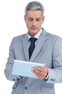 Frowning businessman using digital tablet Foto stock