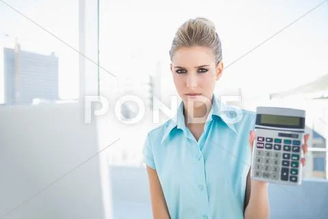 Frowning elegant woman showing calculator Stock Photos