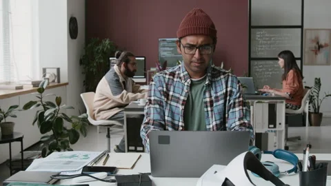 Frowning Indian Male Software Developer Coding on Laptop in Office Stock Footage 285711608