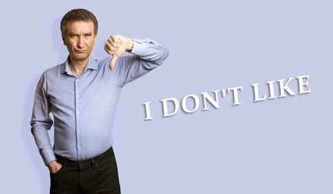 Frowning man showing negative feedback disapproval dislike sign. Stock Photos