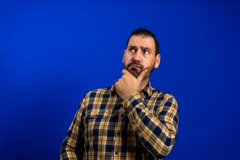 Frowning man thinking expressing doubts and concerns. Hipster male with beard Stock Photos