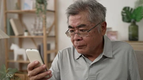 Frowning mature guy concentrated use mobile phone Video stock 165755709