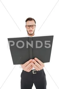 Frowning minister holding out black bible Stock Photos