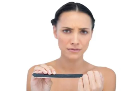 Frowning model with nail file Stock Photos