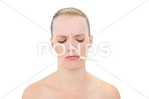 Frowning pretty blonde model using a thermometer Stock Photos