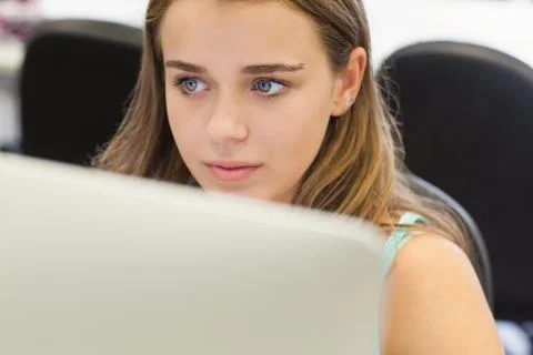 Frowning pretty student working on computer Stock Photos