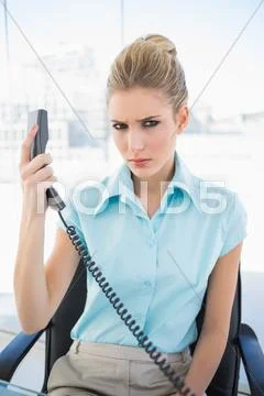 Frowning stylish businesswoman holding the phone Stock Photos
