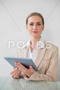 Frowning stylish businesswoman using tablet Stock Photos