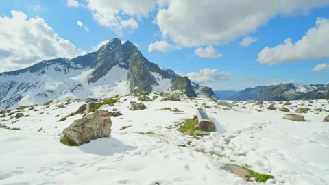 Frozen Alpine Scene with Windblown Snow and Cold Stone Structures near the Sl Stock Footage 308311098