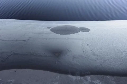 Frozen asphalt surface is covered by cold ice. Texture, structure and stains, Stock Photos