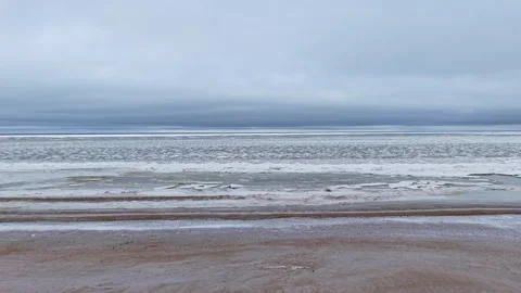 Frozen Baltic seaside with sandy beach snow patches and icy sea 库存影片 331975563