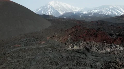 Frozen black lava overlooking snow-capped volcanoes Vídeo Stock 168178802