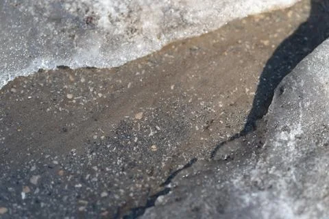 Frozen border highlights asphalt surface with subtle texture changes. Illuminate Stock Photos