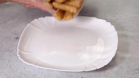 Frozen breaded fish sticks close-up on a plate on the kitchen table Stock Footage 223378681