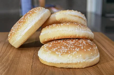 Frozen buns for a burger lie in a stack on a wooden cutting board, the proces Foto stock
