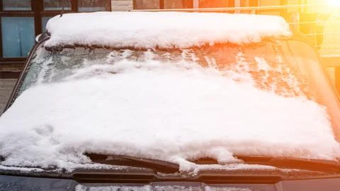 Frozen car windshield covered with ice and snow on a winter day. Close-up vie Stock Photos