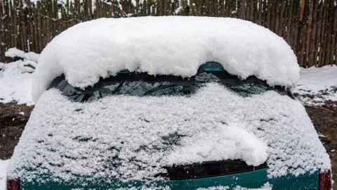 Frozen car windshield covered with ice and snow on a winter day. Close-up vie Stock Photos