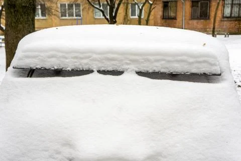 Frozen car windshield covered with ice and snow on a winter day. Close-up vie Stock Photos