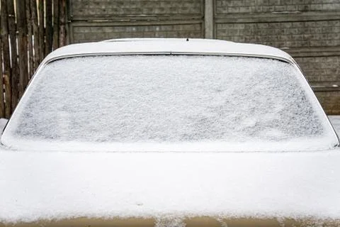 Frozen car windshield covered with ice and snow on a winter day. Close-up vie Stock Photos