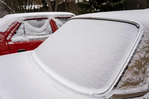 Frozen car windshield covered with ice and snow on a winter day. Close-up vie Stock Photos