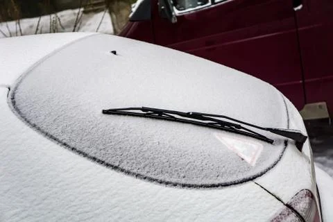 Frozen car windshield covered with ice and snow on a winter day. Close-up vie Stock Photos