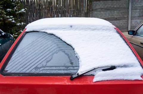 Frozen car windshield covered with ice and snow on a winter day. Close-up vie Stock Photos