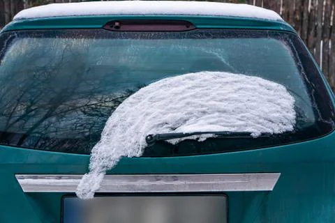 Frozen car windshield covered with ice and snow on a winter day. Close-up vie Stock Photos