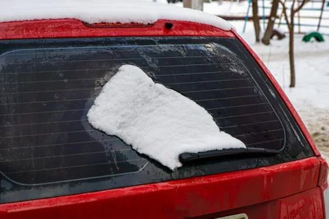 Frozen car windshield covered with ice and snow on a winter day. Close-up vie Stock Photos