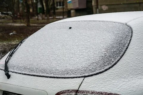 Frozen car windshield covered with ice and snow on a winter day. Close-up vie Stock Photos