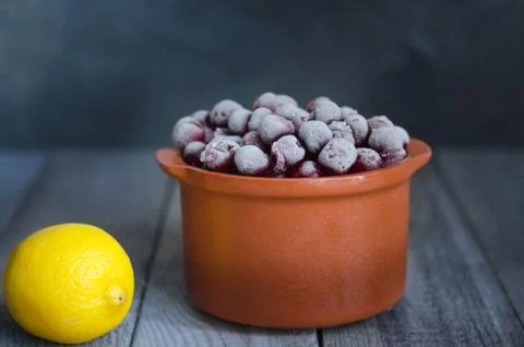 Frozen cherry in a ceramic pot and lemon Stock-Fotos