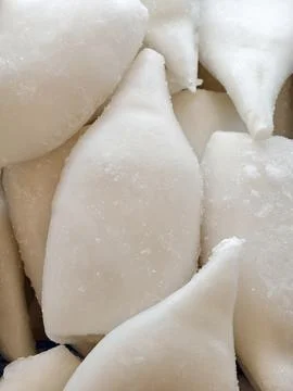 Frozen cleaned squid with natural white appearance lying in a supermarket r.. Stock Photos