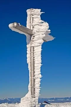 Frozen cross on mountain summit Stock Photos