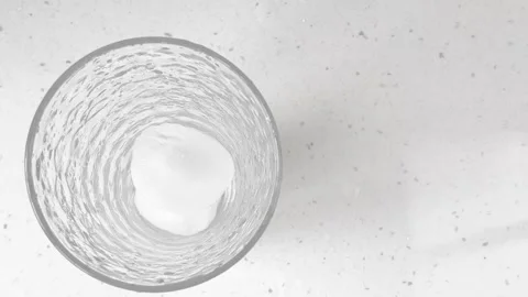 Frozen cubic blocks with crystalline texture falling into a glass. Pieces of ice Vídeos de archivo 332850788