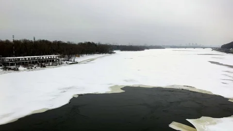 Frozen Dnipro pan shot from beach to Naberezhne Highway. Handheld stabilized pan Video stock 71342142