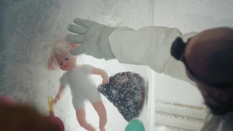 Frozen doll investigation. Gloved technician collects evidence in cold shelter Stock Footage 346474595