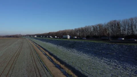 Frozen Dutch Fields: Aerial View of Majestic Landscapes with Highway and Railway Stock Footage 241106825