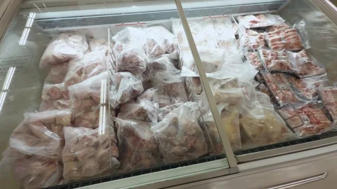 Frozen food items, including raw meat and poultry, stored in transparent plastic Video stock 344431773