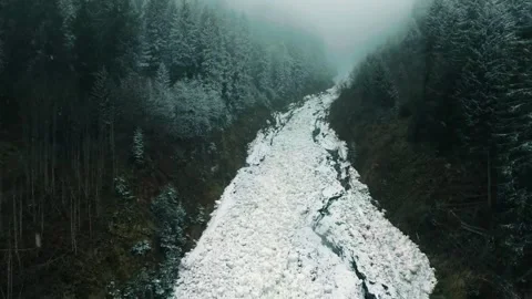 Frozen forest river, icy mountain stream, winter drone footage Stock Footage 311835403