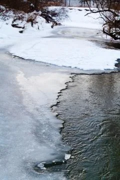 Frozen forest stream in winter Stock Photos